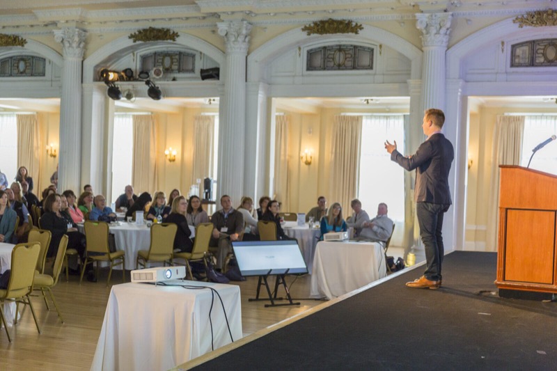 Curt Steinhorst speaking to a leadership audience seated at round tables